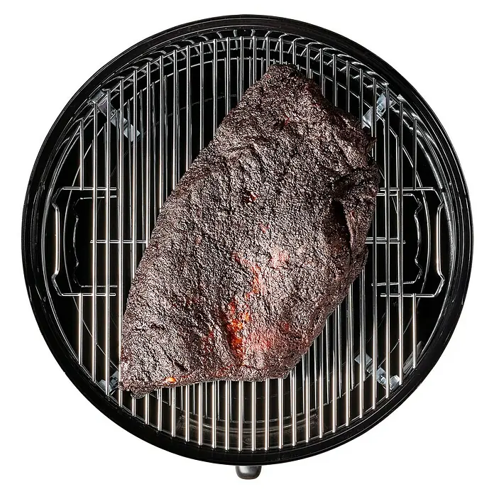 Weber Räucherofen Smokey Mountain Cooker - Durchmesser Grillfläche: 47 cm, Schwarz - Luftaufnahme eines auf einem Grill zubereiteten Rinderbruststücks, das eine dunkle Kruste und köstliche Raucharomen aufweist.