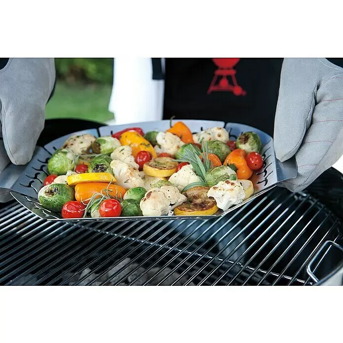 Weber Gemüsekorb - Edelstahl, L x B: 36,6 x 26,4 cm - Metall-Grillkorb mit gemischtem Gemüse, von behandschuhten Händen über einem Grill gehalten.