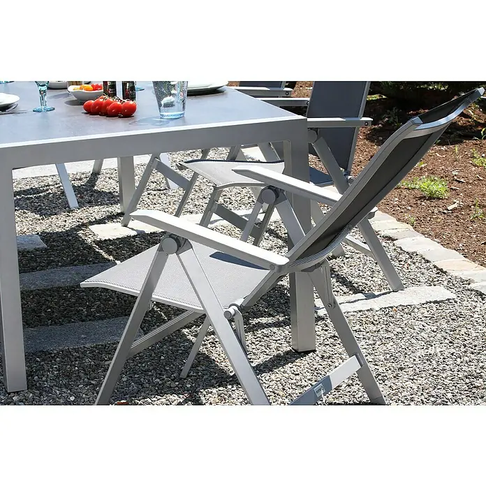 Acamp Klappstuhl Urban - Aluminium, Textil, Rückenlehne verstellbar, Silber, B x T x H: 60 x 66 x 112 cm - Nahaufnahme eines grauen Outdoor-Stuhls mit Armlehnen und einem Tisch mit Speisen im Hintergrund.