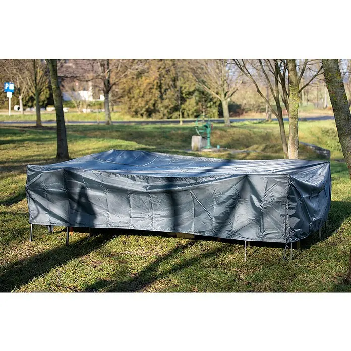 Acamp Sitzgruppen-Schutzhülle Cappa Air - L x B x H: 295 x 210 x 70 cm, Polyester, 130 g/m², Grau - Eine graue Schutzhülle bedeckt eine rechteckige Tischgarnitur im Freien, um sie vor Witterungseinflüssen zu schützen. Das Ensemble steht auf einem Rasen.