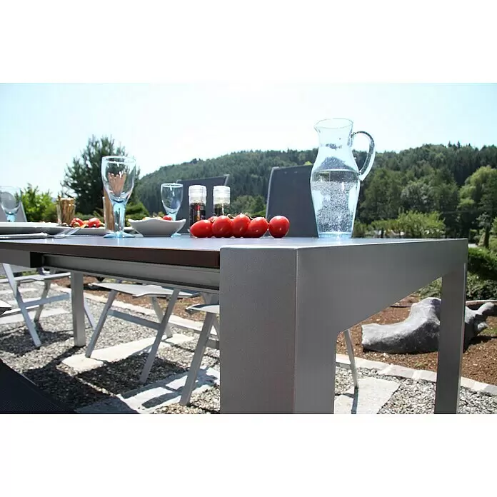 Acamp Gartenmöbel-Set Urban/Extensio - 5 -tlg., Aluminium, HPL, Textil, Klappbar, Anthrazit - Gartentisch mit silbernem Gestell und brauner Platte, für eine Mahlzeit in landschaftlicher Umgebung.