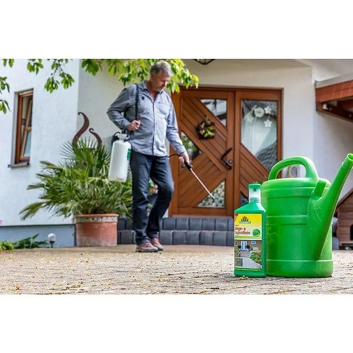 Neudorff Finalsan Wege- & Fugenrein - 1.000 ml, Konzentrat - Bild eines Neudorff Wege- & FugenRein Produkts neben einer grünen Gießkanne, mit einem Mann im Hintergrund, der Unkraut entfernt.