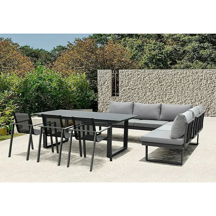 Acamp Gartenmöbel-Set Hollywood - 6 -tlg., Aluminium, Glas, Keramik, Polyester, Anthrazit - Eine graue Gartengarnitur mit Tisch, Stühlen und Sofa vor einer Steinmauer. Perfekt für entspannte Stunden im Freien.
