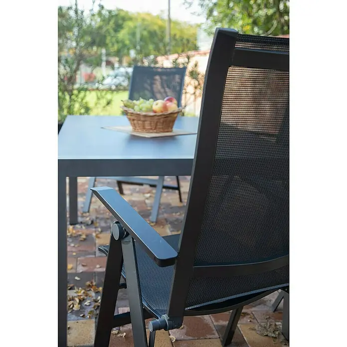 Acamp Gartenmöbel-Set Urban - 5 -tlg., Aluminium, HPL, Acatex, Rückenlehne verstellbar, Anthrazit - Nahaufnahme eines schwarzen Gartenstuhls mit einem Tisch und einem Korb mit Früchten im Hintergrund. Elegantes Design für den Außenbereich.