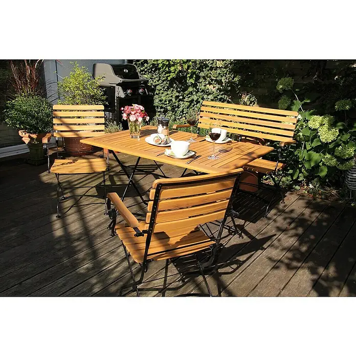 Acamp Gartenmöbel-Set Lindau - 5 -tlg., Akazie, Eisen, Braun - Eine Gartensitzgruppe mit Holztisch und Stühlen auf einer Terrasse, perfekt für Mahlzeiten im Freien.
