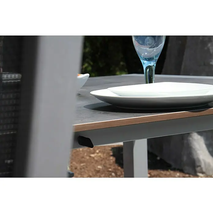 Acamp Gartenmöbel-Set Urban/Extensio - 5 -tlg., Aluminium, HPL, Textil, Klappbar, Anthrazit - Nahaufnahme eines eleganten Gartentisches mit Geschirr, der für Mahlzeiten im Freien bereitsteht. Das moderne Design ergänzt jeden Außenbereich perfekt.