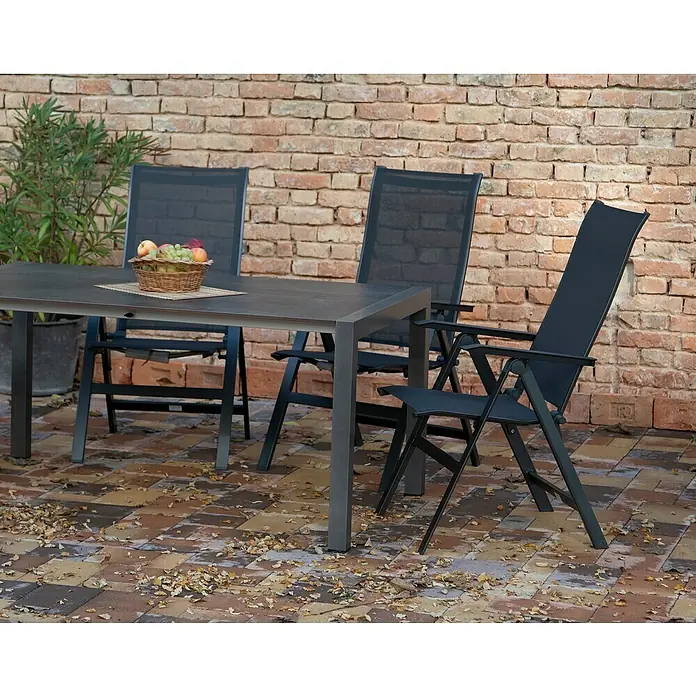 Acamp Gartenmöbel-Set Urban - 5 -tlg., Aluminium, HPL, Acatex, Rückenlehne verstellbar, Anthrazit - Drei graue Gartenstühle und ein Tisch mit Obstkorb stehen auf einer Terrasse. Fokus liegt auf den Gartenmöbeln vor einer Backsteinmauer.