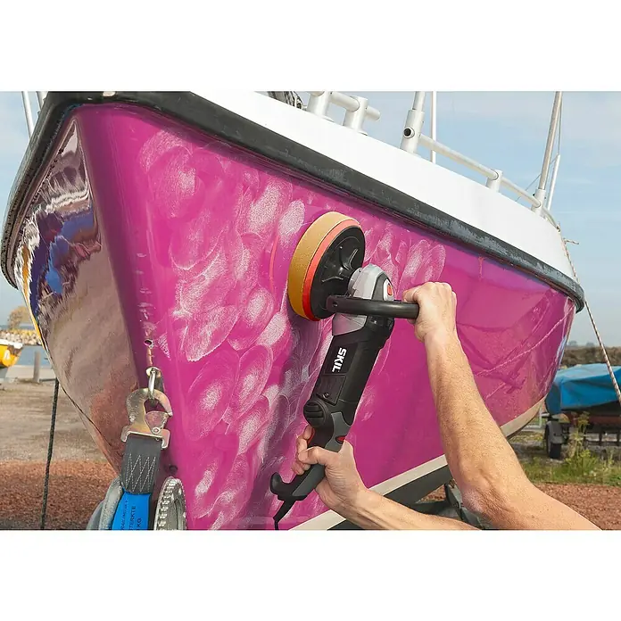 Skil Pulidora 1144AA - 1.200 W, 180 mm, 1.000 r.p.m. - 3.600 r.p.m. - Un hombre pule un barco morado con una pulidora SKIL, trabajando para eliminar las marcas de remolino del casco.
