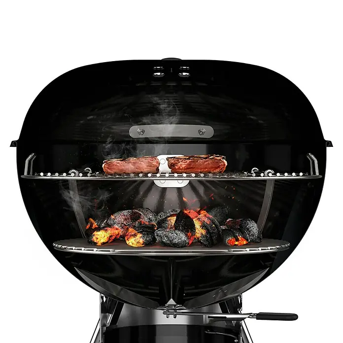 Weber Master-Touch GBS Kugelgrill E-5750 - Durchmesser Grillfläche: 57 cm, Schwarz - Ein schwarzer Kugelgrill mit Steaks auf dem Rost über glühenden Kohlen, bereit zum Grillen für ein perfektes Barbecue-Erlebnis.