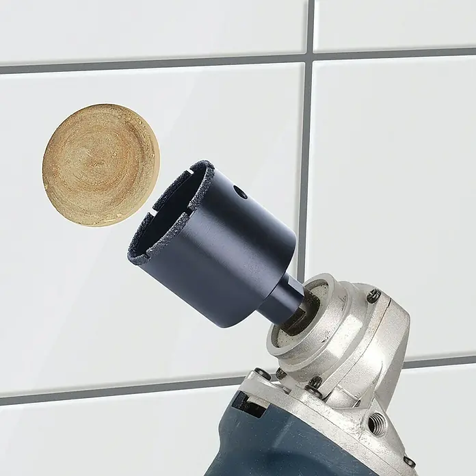Wolfcraft Diamant-Lochsäge Ceramic Winkelschleifer - Durchmesser Bohrloch: 40 mm, Schnitttiefe: 45 mm, M14 Gewinde - Diamantbohrer und ein herausgeschnittenes kreisförmiges Stück aus einer weißen Fliese.