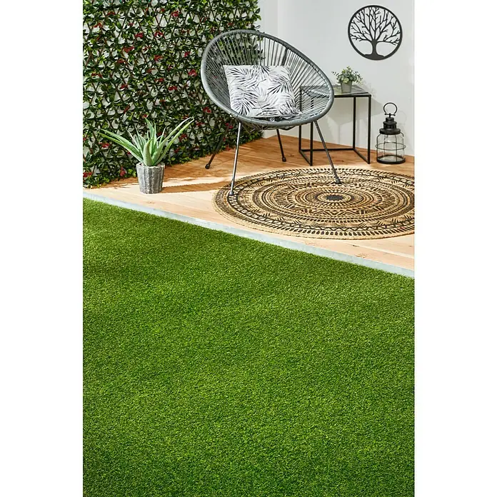 Kunstrasen Olympic - 300 x 133 cm, Grün - Kunstrasen auf einer Terrasse mit Stuhl und Dekorationen. Der Kunstrasen bietet eine grüne, pflegeleichte Alternative für Außenbereiche.