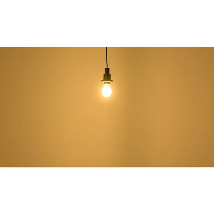 Osram Superstar LED-Lampe Kerzenform E14 klar - E14, Dimmbar, Warmweiß, 470 lm, 5 W - Hängelampe mit Glühbirne vor ockerfarbenem Hintergrund. Die Lampe ist ein schlichter, moderner Akzent in jedem Raum.