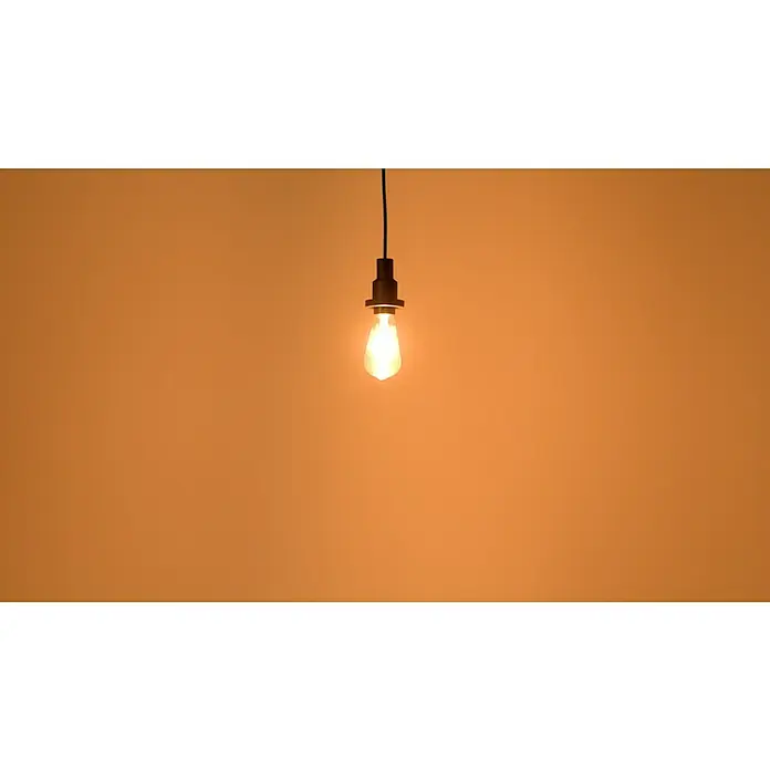 Osram LED-Lampe Vintage Edition 1906 Globe-Form E27 - E27, Nicht Dimmbar, Warmweiß, 410 lm, 4 W, Birne - Einzelne, dekorative Edison-Glühbirne mit warmem Licht, hängt an einem schwarzen Kabel vor einem orangefarbenen Hintergrund.