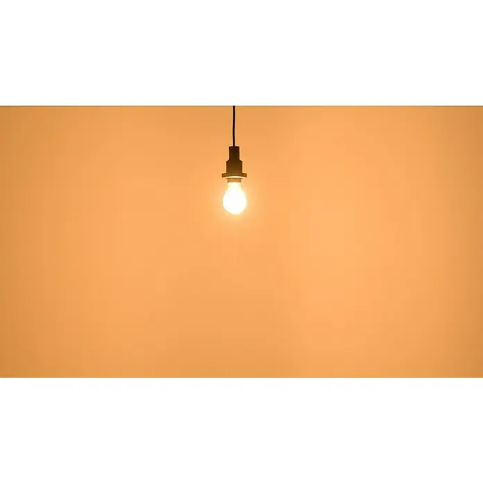 Osram Star LED-Lampen Set Glühlampenform E27 - E27, Nicht Dimmbar, Warmweiß, 806 lm, 7 W, 5 Stk., Klar - Eine einzelne Glühbirne hängt an einem Kabel vor einem orangefarbenen Hintergrund und spendet warmes Licht. Eine minimalistische Lampe.