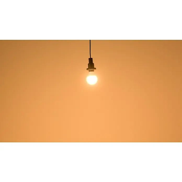 Osram LED-Lampen Set Glühlampenform E27 matt - E27, Nicht Dimmbar, Warmweiß, 806 lm, 9 W, 5 Stk. - Hängende Glühbirne mit warmem Licht vor einem orangefarbenen Hintergrund. Die Lampe strahlt Helligkeit und Wärme aus und erhellt den Raum sanft.