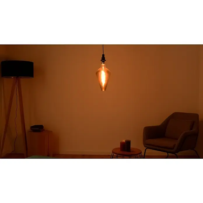 Osram LED-Lampe Vintage Edition 1906 Glühlampenform E27 - E27, Dimmbar, Warmweiß, 140 lm, 4 W - Gemütliches Wohnzimmer mit einem auffälligen Tropfenlampenschirm, der warmes Licht verbreitet und eine einladende Atmosphäre schafft.