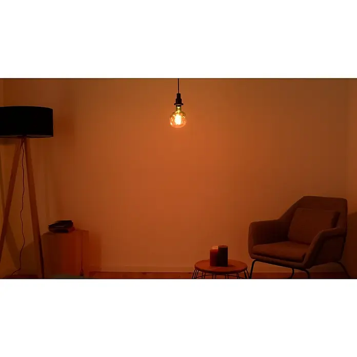 Osram LED-Lampe Vintage Edition 1906 Globe-Form E27 - E27, Dimmbar, Warmweiß, 180 lm, 4,5 W - Innenaufnahme mit einem dekorativen Edison-Glühbirnenanhänger, der einen warmen Schein über einem gemütlichen Wohnraum wirft.