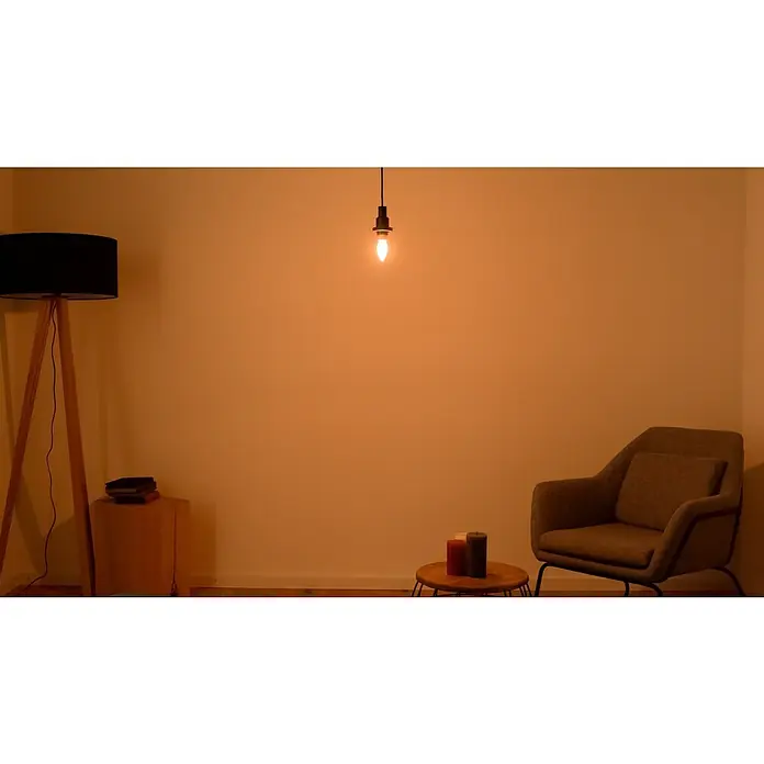 Osram LED-Lampe Vintage Edition 1906 Birnenform E14 - E14, Dimmbar, Warmweiß, 250 lm, Kerze, Gold - Gemütliches Interieur mit Stehlampe, Pendelleuchte und Sessel in warmem Licht. Wohnliches Ambiente für entspannte Stunden.