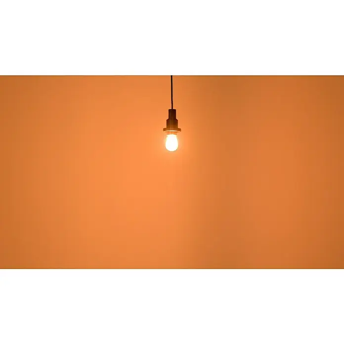 Ledvance LED-Lampe Glühlampenform E27 klarE27, Nicht Dimmbar, Warmweiß, 840 lm, 4 W - Glühbirne mit warmem Licht hängt von der Decke und beleuchtet den Raum, wodurch eine gemütliche Atmosphäre entsteht.