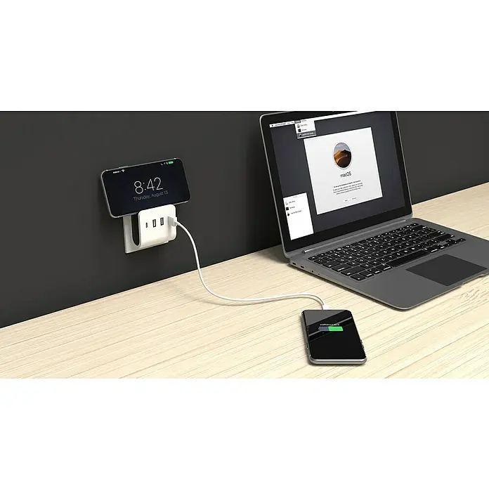 REV USB-Ladegerät Quad - 4-fach, Weiß, USB-A-Buchse, USB C-Kupplung - Ein Smartphone, das an einer Ladestation an der Wand befestigt ist, und ein weiteres, das über ein Kabel mit dem Laptop verbunden ist.