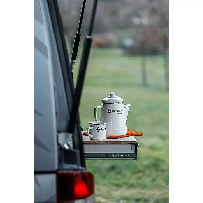 Petromax Perkolator Perkomax - Weiß, 1,3 l - Weißer Emaille-Perkolator und Tasse von Petromax auf einem ausziehbaren Regal eines Campingbusses.