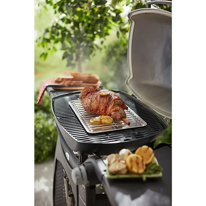 Weber Hitzeschild - Passend für: Weber Q 200 / Q 300 / Q 2000 / Q 3000 - Serie - Der Weber Gasgrill mit einem köstlichen Lammbraten, der mit Zitrone und Knoblauch verfeinert wurde, bereit für ein Festmahl im Freien.