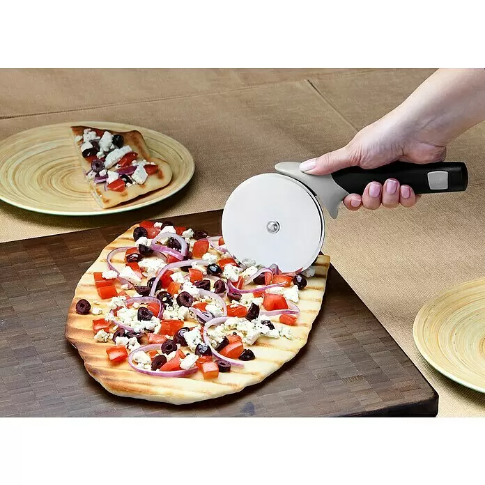 Weber Pizzaschneider - Klingendurchmesser 10 cm, Edelstahl - Eine Hand schneidet eine Fladenbrotpizza auf einem Holzbrett mit einem Pizzaschneider mit silberner Klinge und schwarzem Griff.