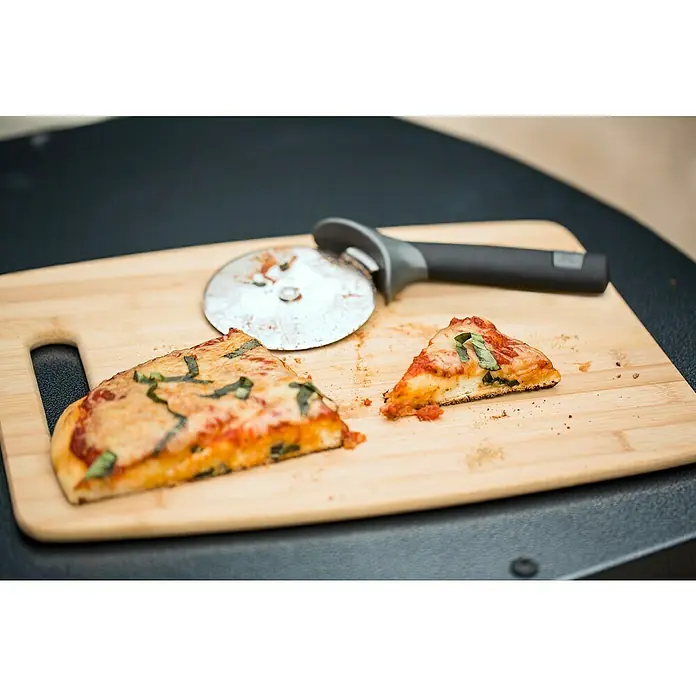 Weber Pizzaschneider - Klingendurchmesser 10 cm, Edelstahl - Eine Nahaufnahme von zwei Pizzastücken auf einem Holzbrett mit einem Pizzaschneider. Köstliche Pizza mit Basilikum und Käse.