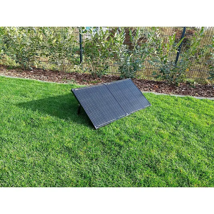 Technaxx Solarkoffer TX-215 - Max. Leistung: 100 W, 107 x 57 x 4 cm - Eine tragbare Solarpanel-Einheit steht auf einem grünen Rasen, ideal für umweltfreundliche Energielösungen im Freien.