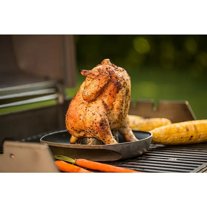 Weber Style Soporte para asar pollos para barbacoa - Aluminio - Un suculento pollo a la cerveza cocinado en una parrilla, rodeado de mazorcas de maíz y zanahorias para una deliciosa barbacoa.