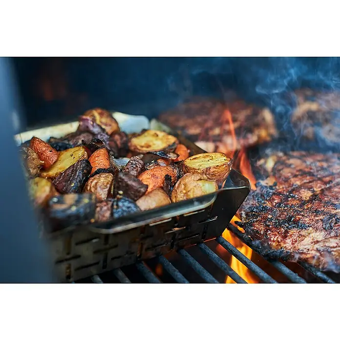 Weber Style Gemüsekorb - Edelstahl, 29,5 x 35 cm - Ein Grill mit Gemüse in einer Metallpfanne und Steaks, die auf dem Grill zubereitet werden, allesamt köstlich.