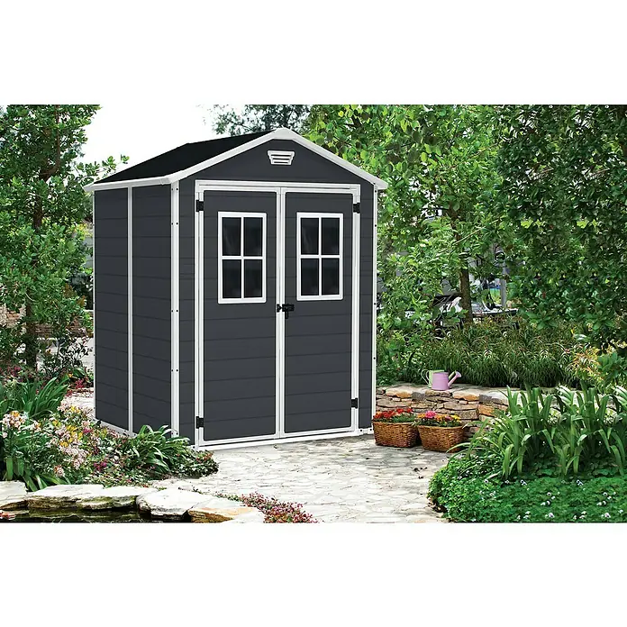 Keter Gerätehaus Manor 6x5 - Außenmaß inkl. Dachüberstand (B x T): 185 x 152 cm, Kunststoff, Anthrazit/Weiß - Ein graues Gerätehaus mit weißen Akzenten und Fenstern im Garten. Das Gartenhaus bietet Stauraum und fügt sich in die Gartenumgebung ein.