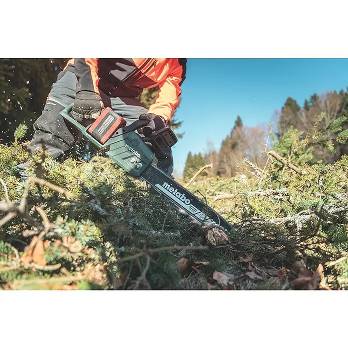 Metabo CAS 18V Akku-Kettensäge MS36-18 LTXBL40 - 18 V, Li-Ionen, Ohne Akku, Schwertlänge: 40 cm - Nahaufnahme einer Metabo Kettensäge beim Schneiden von Ästen. Die Kettensäge ist grün und schwarz, und die Äste sind grün und braun.