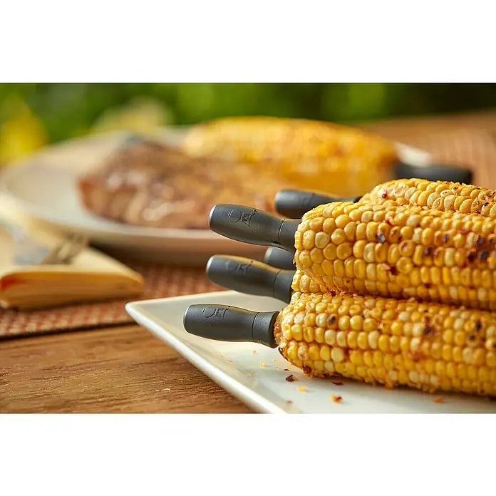 Weber Maiskolbenhalter - 8 Stk. - Gegrillter Maiskolben mit praktischen Haltern auf einem Tisch.