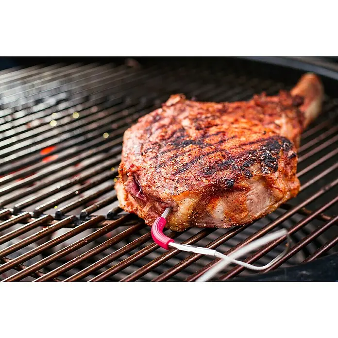 Weber Ersatz-Messfühler iGrill Pro - Passend für: Weber Thermometer iGrill, Kerntemperaturmessung - Ein saftiges Tomahawk-Steak mit Grillspuren und einem Thermometer auf einem Grillrost.
