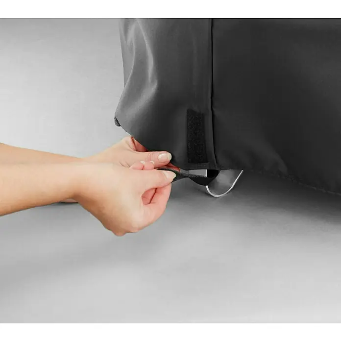 Weber Grill-Schutzhülle Fireplace - Passend für: Weber Feuerstelle Fireplace - Detailaufnahme einer schwarzen Schutzhülle für Grill mit Kordelzug, die von Händen fixiert wird, um den Schutz zu verstärken.