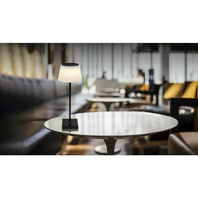 Globo Akku-Tischleuchte GREGOIR - 4 W, Warmweiß, Schwarz, Weiß - Elegante Tischleuchte mit plissiertem Schirm auf einem runden Tisch, ideal für stimmungsvolle Beleuchtung in stilvollen Innenräumen.