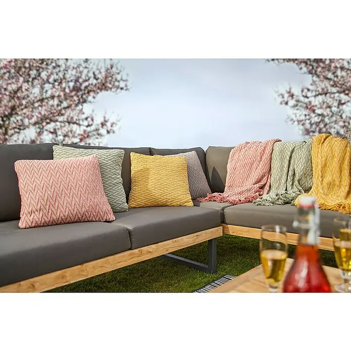 Kissen Graffiti - Yellow, 45 x 45 cm, 100 % Baumwolle - Gartenmöbel-Set mit farbenfrohen Kissen und Decken auf einer Terrasse mit blühenden Bäumen.