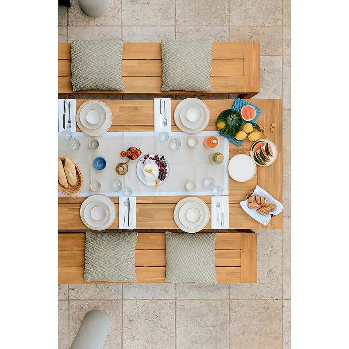 Sunfun Laura Gartentisch - L x B x H: 220 x 100 x 76 cm, Akazie, Rechteckig, Naturbraun - Ein gedeckter Tisch mit Geschirr, Besteck und Speisen für ein sommerliches Essen im Freien, mit Kissen auf den Bänken für Komfort.
