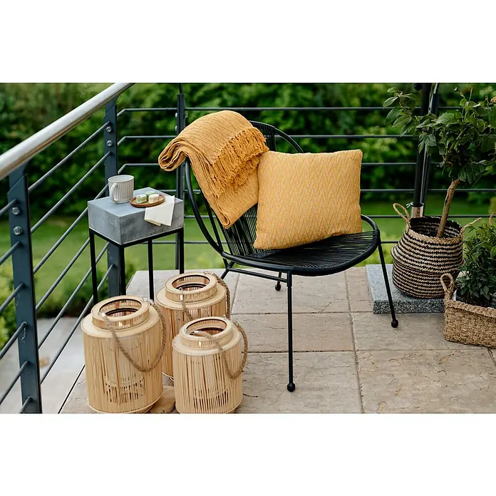 Gartensessel String - Metall, Schwarz, B x T x H: 62 x 73 x 77 cm - Nahaufnahme eines stilvollen Außenbereichs mit gelbem Kissen und Überwurf auf einem Stuhl, ergänzt durch Laternen und Beistelltisch.