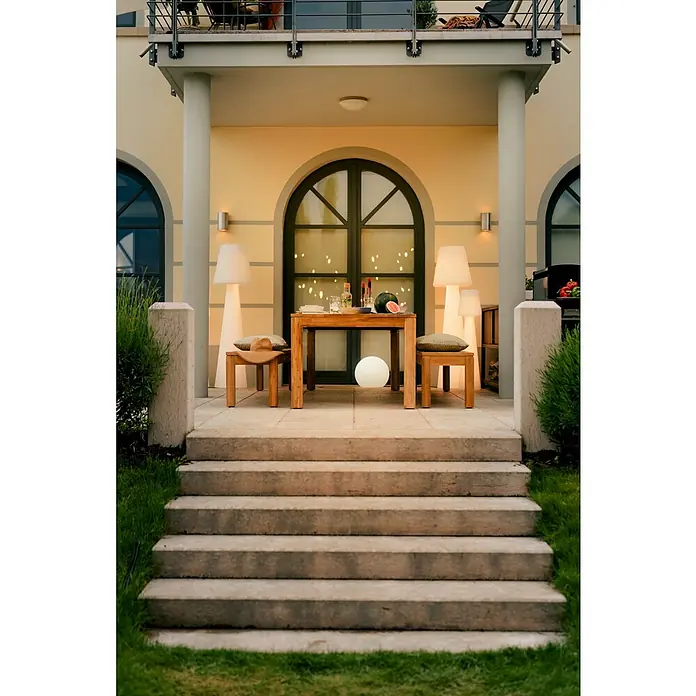 New Garden Design-Außenleuchte Lola 165 - Höhe: 165 cm, Leistung: 22 W, Warmweiß - Eine Außenterrasse mit Holztisch, Bänken und Lampen lädt zum Verweilen ein. Der perfekte Ort, um den Sommer zu genießen.
