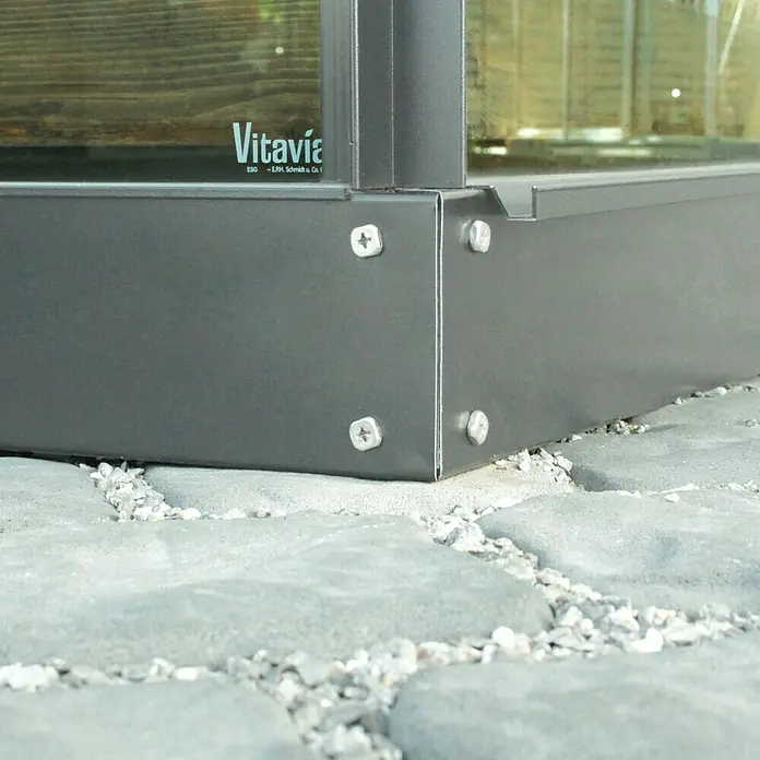Vitavia Gewächshaus-Fundament - 154 x 192,2 x 12,5 cm, Passend für: Vitavia Gewächshaus Calypso 3000, Schwarz - Nahaufnahme eines Vitavia-Gewächshausrahmens mit Befestigungsschrauben auf einem gepflasterten Untergrund.