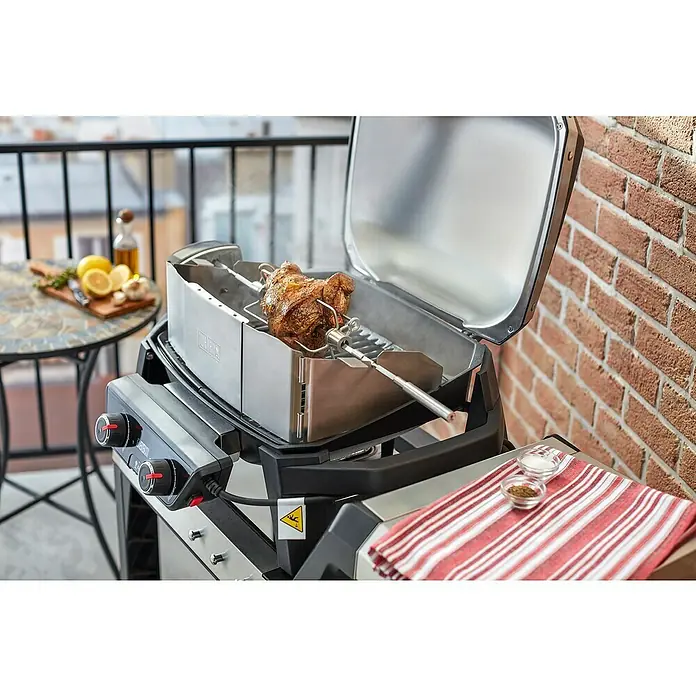 Weber Drehspieß - Länge: 16 cm, Passend für: Weber Elektrogrill Pulse 1000 / 2000 - Nahaufnahme eines Weber Grills mit Drehspieß, auf dem ein Braten zubereitet wird, perfekt für köstliche Grillgerichte im Freien.