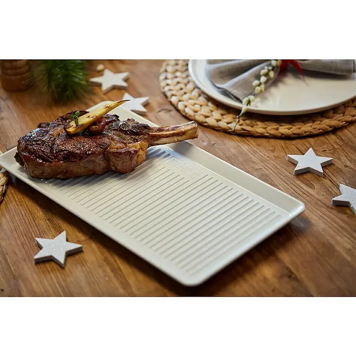 Weber Serviertablett Porzellan - L x B: 40,3 x 22,1 cm, Keramik, Weiß - Ein saftiges Steak auf einer geriffelten Servierplatte, umgeben von dekorativen Sternen, präsentiert auf einem warmen Holztisch.