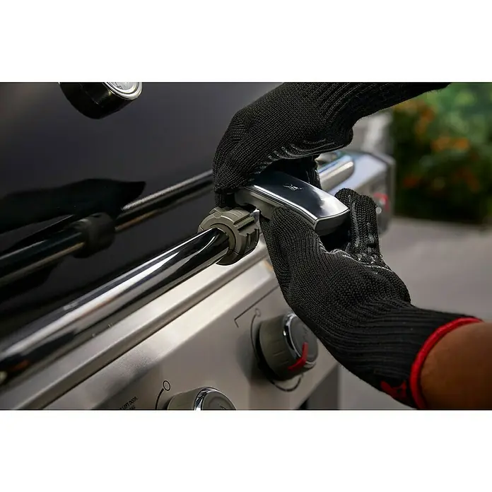 Weber Grifflicht - Passend für: Weber Gasgrills Genesis II / Spirit II / Genesis, Spirit & Summit - Serie (ab Baujahr 2007) - Nahaufnahme einer Person mit Grillhandschuhen, die einen Grillknopf an einem hochwertigen Grill bedient.