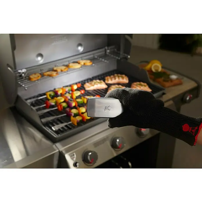 Weber Grifflicht - Passend für: Weber Gasgrills Genesis II / Spirit II / Genesis, Spirit & Summit - Serie (ab Baujahr 2007) - Ein Weber Grill wird mit Würstchen und Lachs verwendet, während eine Person einen Weber Grill Thermometer benutzt.