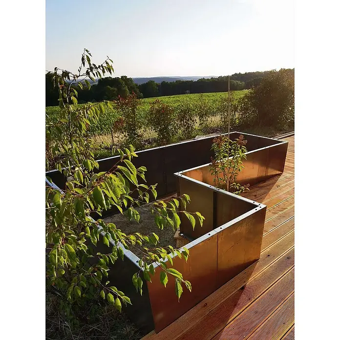 Palatino Hochbeet Urban L-Form - 200 x 200 x 70 cm, Stahl, Rostbraun - Hochbeet aus Kupfer auf Holzterrasse mit Blick auf eine grüne Landschaft. Ideal für Gartenliebhaber mit Stil.