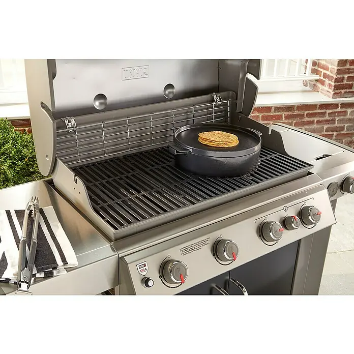 Weber Dutch Oven 2in1 - L x B x H: 33,5 x 42,37 x 12,27 cm, Gusseisen - Ein Weber Grill mit einer schwarzen Grillpfanne und Tortillas darauf. Das perfekte Gerät für köstliche Grillgerichte im Freien.