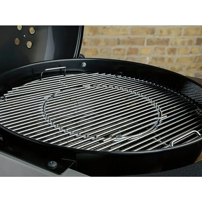 Weber Barbacoa de carbón Performer premium GBS 57 - Diámetro de la superficie de la parrilla: 57 cm, Negro - Primer plano de una parrilla Weber negra con parrillas brillantes y un inserto redondo, ideal para asados al aire libre.