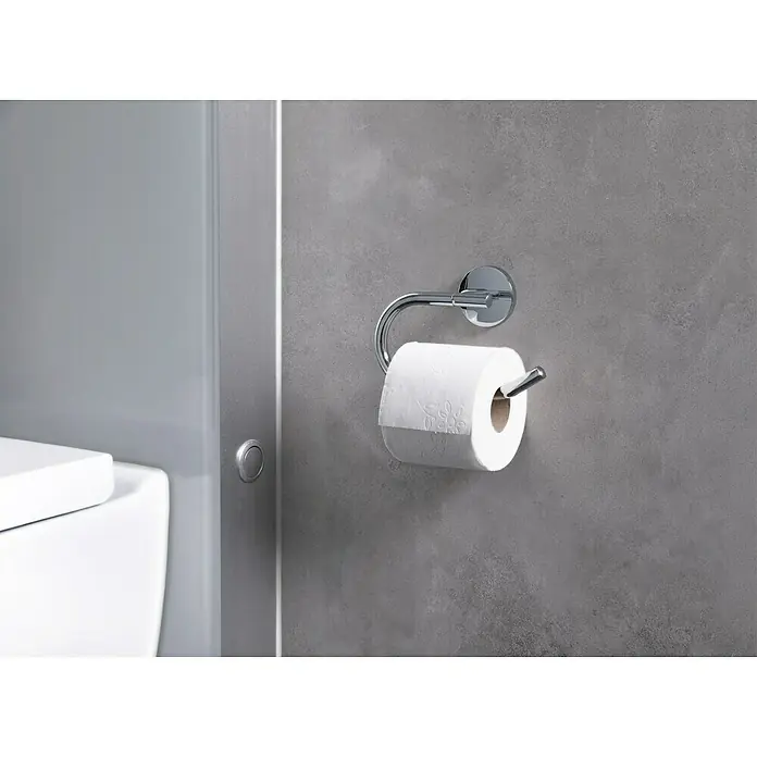 Venus Marina Toilettenpapierhalter - Ohne Deckel, Chrom, Glänzend - Eine Nahaufnahme eines Toilettenpapierspenders aus Chrom mit einer weißen Toilettenpapierrolle an einer grauen Wand.